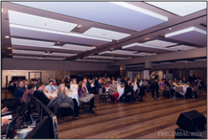 Varias personas se hallan sentadas en las butacas de una sala de conferencias. 